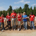 Group of volunteers shoveling new dirt for playground