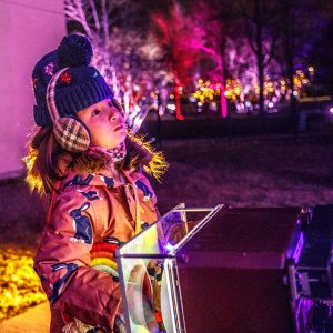 young girl looks up at lights in wonder